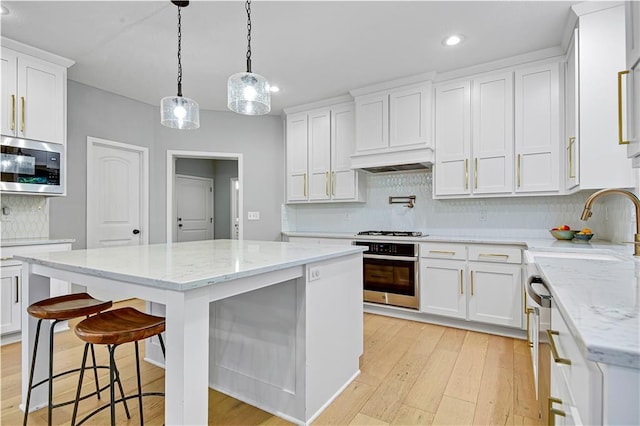 20487 W 108th St, Olathe, KS 66061 - kitchen with appliances with stainless steel finishes, decorative backsplash, recessed lighting, white cabinetry, and light wood-style flooring