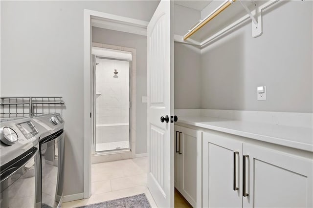 20487 W 108th St, Olathe, KS 66061 - washroom featuring washing machine and clothes dryer, light tile patterned floors, and cabinet space