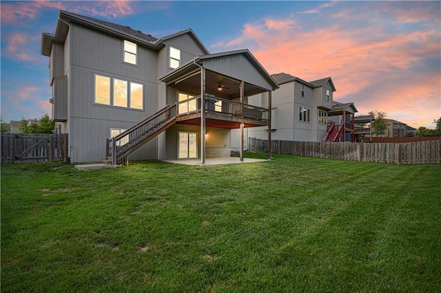 20487 W 108th St, Olathe, KS 66061 - back of house at dusk with stairs, a patio, a fenced backyard, a ceiling fan, and a gate