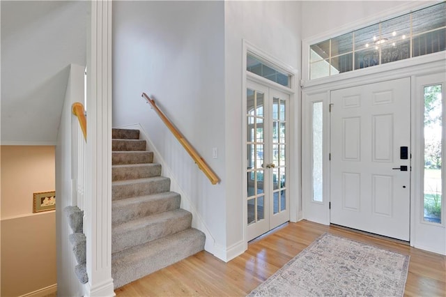 5010 W 161st Ter, Overland Park, KS 66085 - foyer entrance featuring wood finished floors, french doors, a high ceiling, and stairs