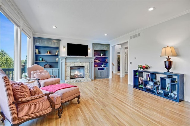 5010 W 161st Ter, Overland Park, KS 66085 - living room featuring decorative columns, light wood-style floors, crown molding, a fireplace, and recessed lighting