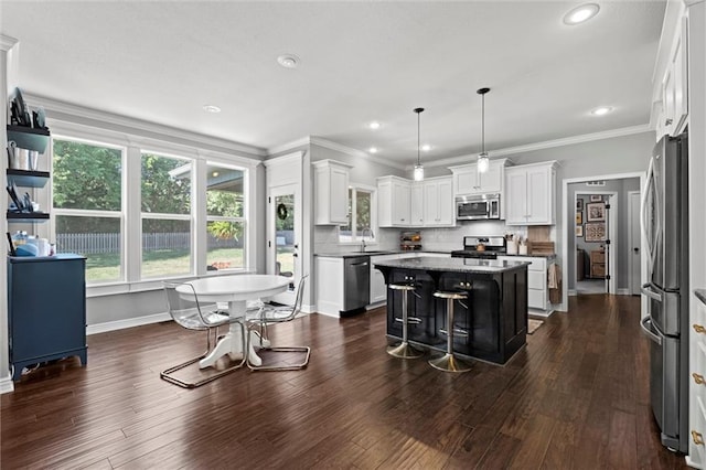 316 SE Hackamore Dr, Lees Summit, MO 64082 - kitchen featuring appliances with stainless steel finishes, a kitchen island, a breakfast bar area, white cabinetry, and dark wood-style floors