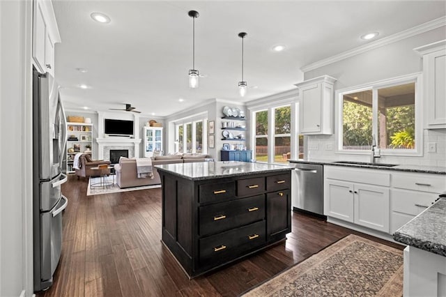 316 SE Hackamore Dr, Lees Summit, MO 64082 - kitchen featuring stainless steel appliances, open floor plan, white cabinets, crown molding, and dark cabinetry