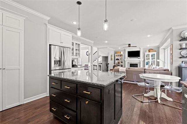 316 SE Hackamore Dr, Lees Summit, MO 64082 - kitchen with stainless steel fridge with ice dispenser, white cabinetry, a ceiling fan, a fireplace, and dark wood-type flooring
