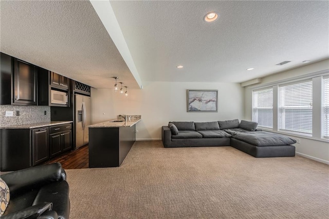 3536 SW Dana Ave, Lees Summit, MO 64082 - living area with dark colored carpet, a textured ceiling, a chandelier, and recessed lighting
