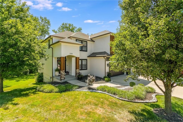 3536 SW Dana Ave, Lees Summit, MO 64082 - view of front of house with stucco siding, a front yard, concrete driveway, a garage, and roof with shingles