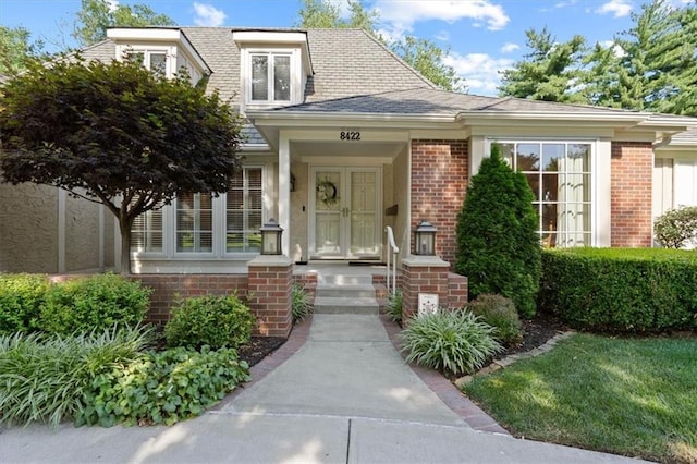 8422 Reinhardt Ln, Leawood, KS 66206 - view of exterior entry with brick siding and roof with shingles