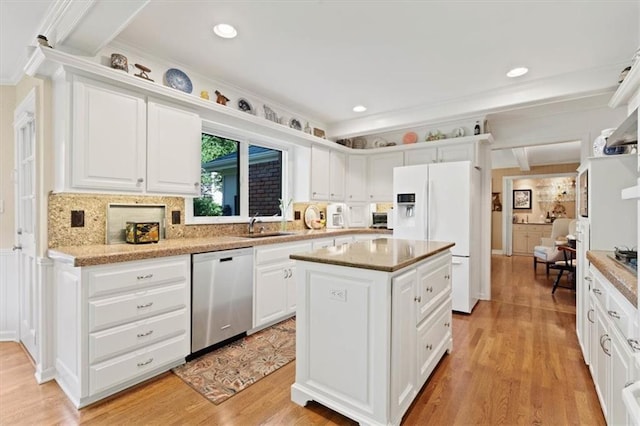 8422 Reinhardt Ln, Leawood, KS 66206 - kitchen with stainless steel dishwasher, white refrigerator with ice dispenser, a center island, light wood-style flooring, and white cabinetry