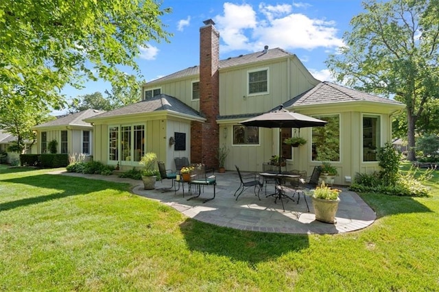 8422 Reinhardt Ln, Leawood, KS 66206 - rear view of house featuring board and batten siding, a chimney, a patio area, and a yard