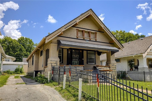 3509 Bellefontaine Ave, Kansas City, MO 64128 - victorian home with a fenced front yard, driveway, a porch, and stucco siding