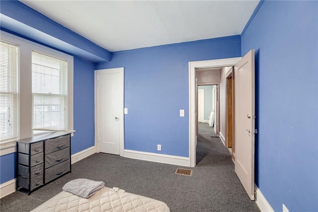 3509 Bellefontaine Ave, Kansas City, MO 64128 - unfurnished bedroom featuring dark colored carpet and baseboards