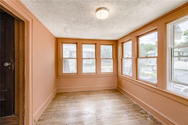 3509 Bellefontaine Ave, Kansas City, MO 64128 - unfurnished sunroom featuring a textured ceiling and wood-type flooring