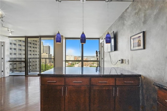 600 E Admiral Blvd Unit 1703, Kansas City, MO 64106 - kitchen featuring wood finished floors, dark stone counters, floor to ceiling windows, decorative light fixtures, and a peninsula