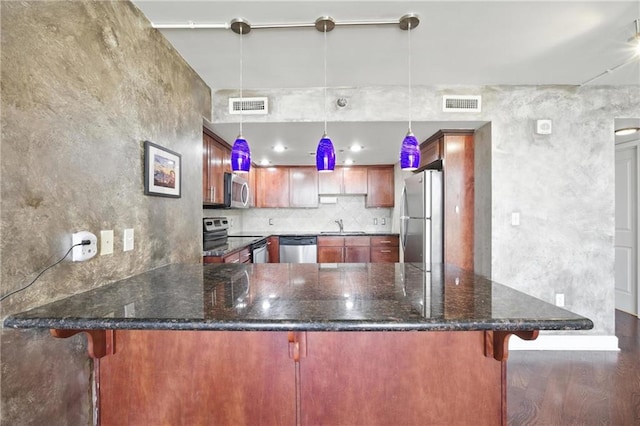 600 E Admiral Blvd Unit 1703, Kansas City, MO 64106 - kitchen featuring stainless steel appliances, a peninsula, dark stone countertops, wood finished floors, and backsplash