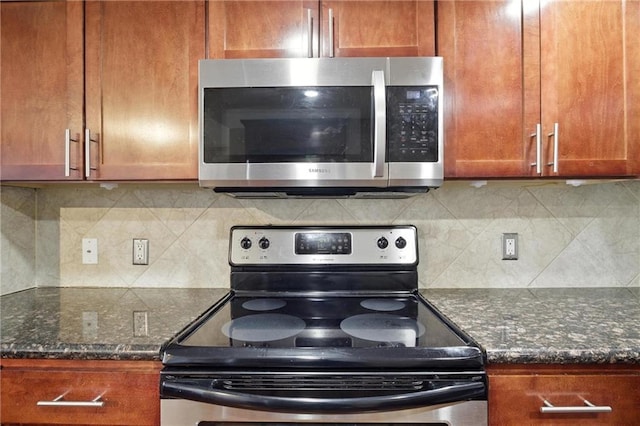 600 E Admiral Blvd Unit 1703, Kansas City, MO 64106 - kitchen featuring appliances with stainless steel finishes, tasteful backsplash, brown cabinetry, and dark stone counters