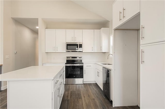 1832 N 31st St, Kansas City, KS 66104 - kitchen featuring appliances with stainless steel finishes, dark wood-style flooring, white cabinets, a center island, and recessed lighting