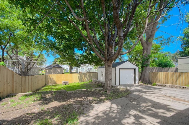 1832 N 31st St, Kansas City, KS 66104 - fenced backyard with driveway, an outbuilding, and a garage