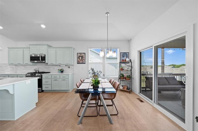 118 NW Grady Ct, Lees Summit, MO 64081 - kitchen featuring stainless steel appliances, light wood-style floors, light countertops, plenty of natural light, and vaulted ceiling
