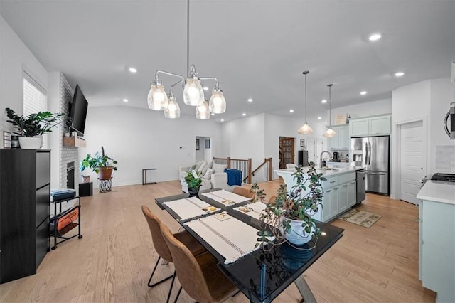 118 NW Grady Ct, Lees Summit, MO 64081 - dining area featuring light wood-style flooring, recessed lighting, a fireplace, and a chandelier