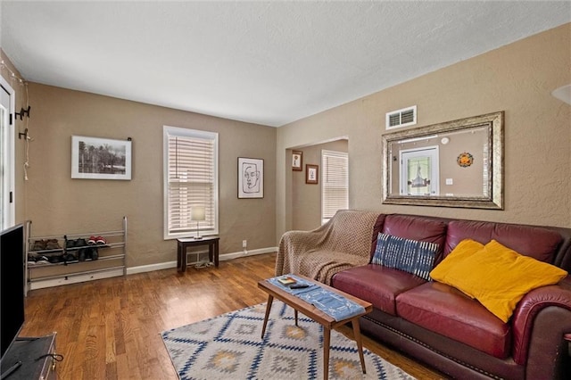 6016 Harrison St, Kansas City, MO 64110 - living room with wood finished floors and a textured wall