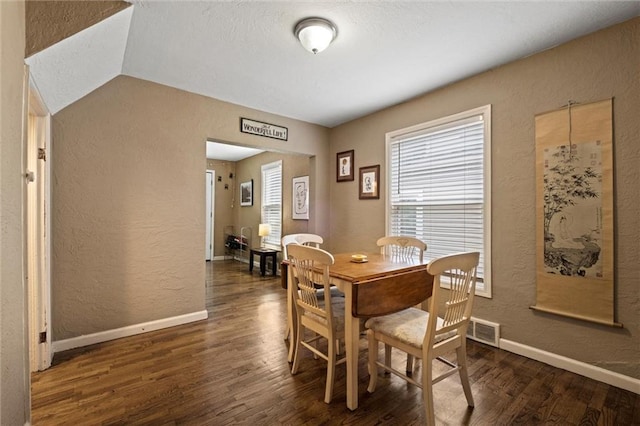 6016 Harrison St, Kansas City, MO 64110 - dining space featuring a textured wall, wood finished floors, a textured ceiling, and vaulted ceiling