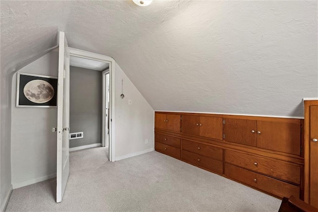 6016 Harrison St, Kansas City, MO 64110 - bonus room featuring a textured ceiling, lofted ceiling, and light colored carpet