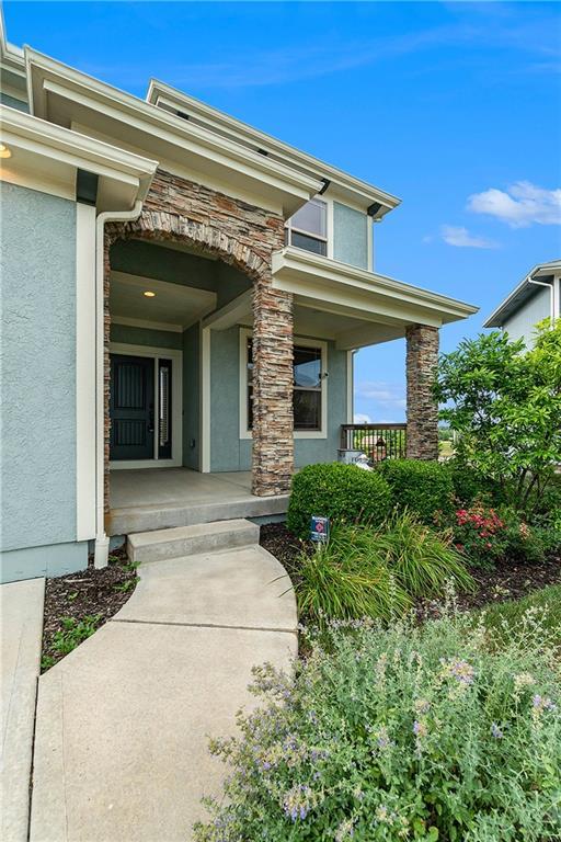 16699 S Chalet Dr, Olathe, KS 66062 - property entrance featuring a porch, stucco siding, and stone siding
