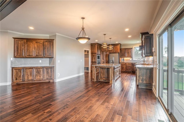 16699 S Chalet Dr, Olathe, KS 66062 - kitchen featuring crown molding, dark wood-type flooring, stainless steel fridge with ice dispenser, backsplash, and a kitchen breakfast bar