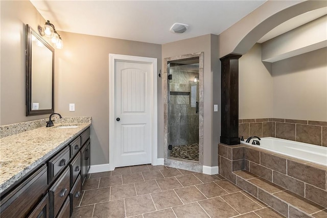 16699 S Chalet Dr, Olathe, KS 66062 - bathroom featuring vanity, a bath, a stall shower, decorative columns, and tile patterned flooring