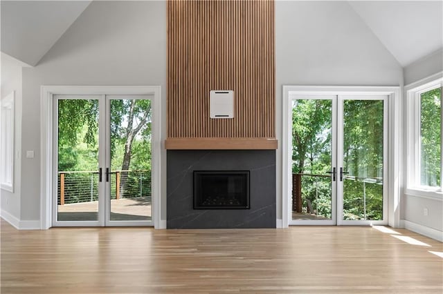 2616 W 112th St, Leawood, KS 66211 - unfurnished living room with high vaulted ceiling, wood finished floors, healthy amount of natural light, and a glass covered fireplace