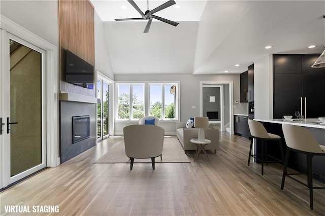 2616 W 112th St, Leawood, KS 66211 - living room with a glass covered fireplace, a ceiling fan, light wood-style floors, high vaulted ceiling, and recessed lighting