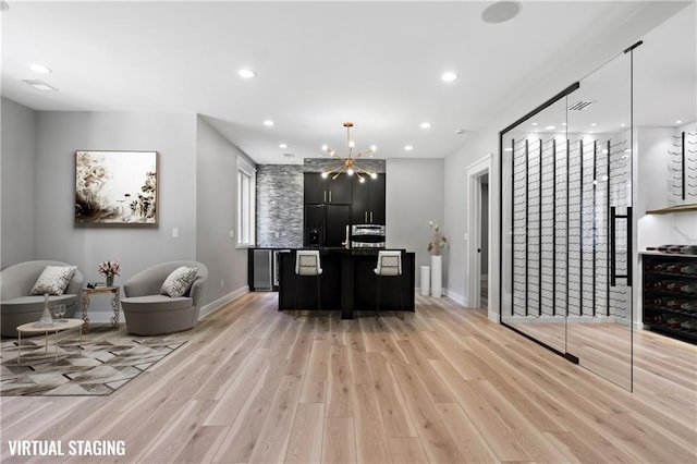 2616 W 112th St, Leawood, KS 66211 - kitchen featuring open floor plan, light wood-style floors, dark cabinetry, recessed lighting, and a chandelier