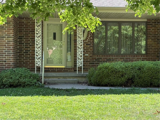 105 N Hayes St, Garnett, KS 66032 - doorway to property with brick siding and a lawn