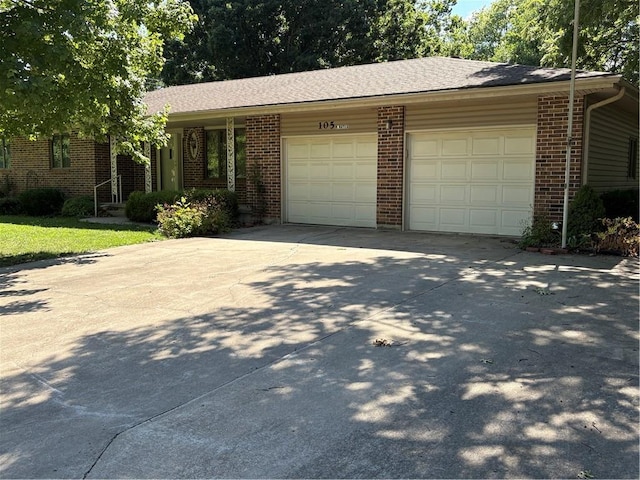 105 N Hayes St, Garnett, KS 66032 - ranch-style house featuring a garage, brick siding, and concrete driveway