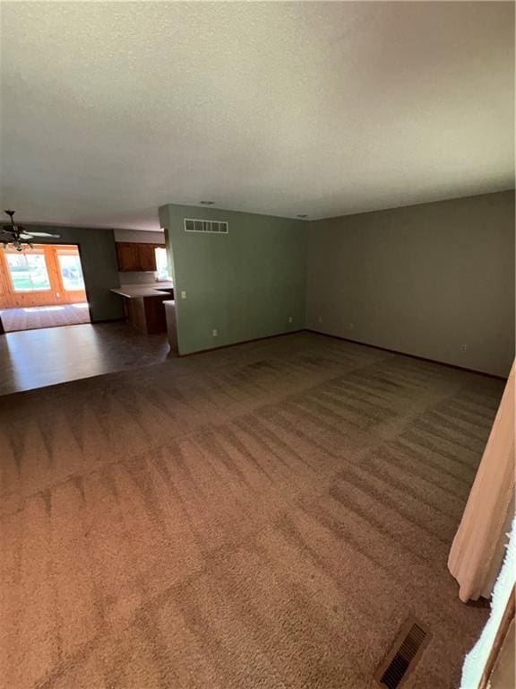105 N Hayes St, Garnett, KS 66032 - unfurnished living room featuring carpet flooring, a textured ceiling, and ceiling fan