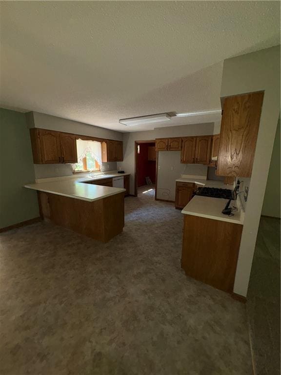 105 N Hayes St, Garnett, KS 66032 - kitchen featuring a peninsula, a textured ceiling, brown cabinets, and light countertops