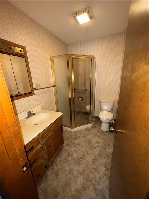 105 N Hayes St, Garnett, KS 66032 - bathroom with vanity, wallpapered walls, and a stall shower