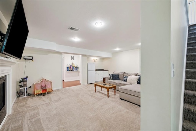 1311 SE Eastridge Cir, Blue Springs, MO 64014 - living area featuring stairs, carpet flooring, and a glass covered fireplace