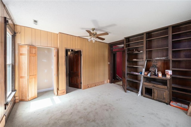 118 Spruce St, Leavenworth, KS 66048 - unfurnished bedroom with light colored carpet, wooden walls, and ceiling fan