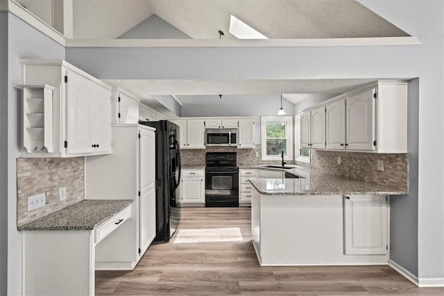 17277 W 157th St, Olathe, KS 66062 - kitchen with black appliances, a peninsula, vaulted ceiling, light wood-style floors, and tasteful backsplash