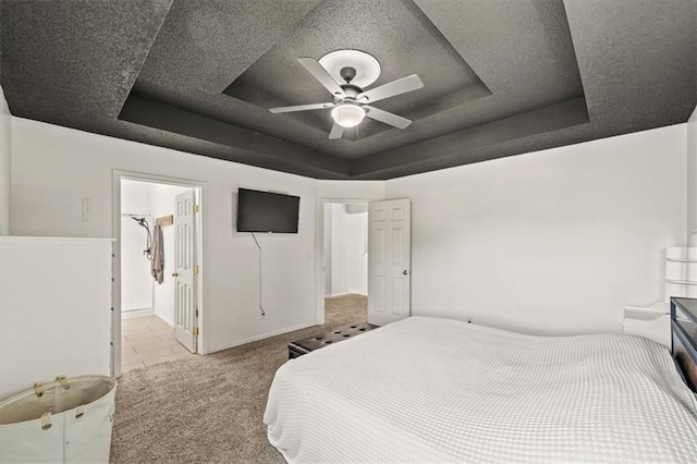 17277 W 157th St, Olathe, KS 66062 - carpeted bedroom featuring a tray ceiling, ensuite bathroom, and a ceiling fan