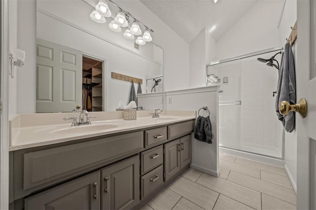 17277 W 157th St, Olathe, KS 66062 - bathroom with double vanity, a shower stall, lofted ceiling, a textured ceiling, and a spacious closet