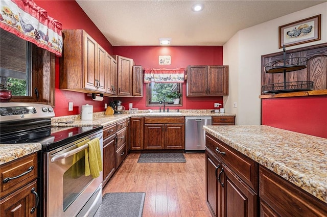 9750 SW 200th St, Smithville, MO 64089 - kitchen with appliances with stainless steel finishes, light wood-type flooring, light stone countertops, recessed lighting, and a textured ceiling