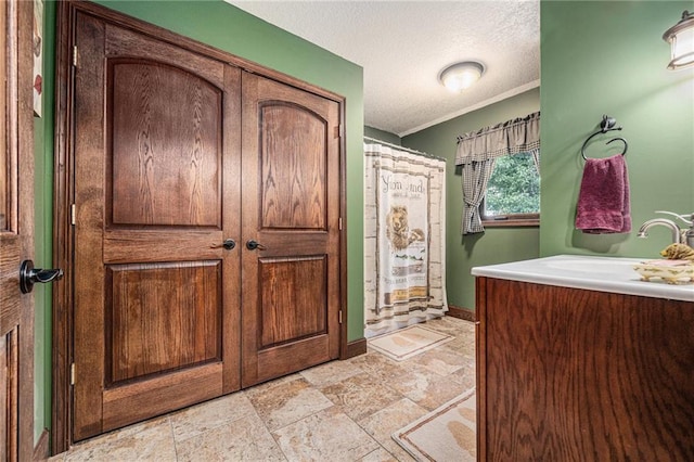 9750 SW 200th St, Smithville, MO 64089 - bathroom with stone tile flooring, a textured ceiling, vanity, ornamental molding, and a shower with curtain