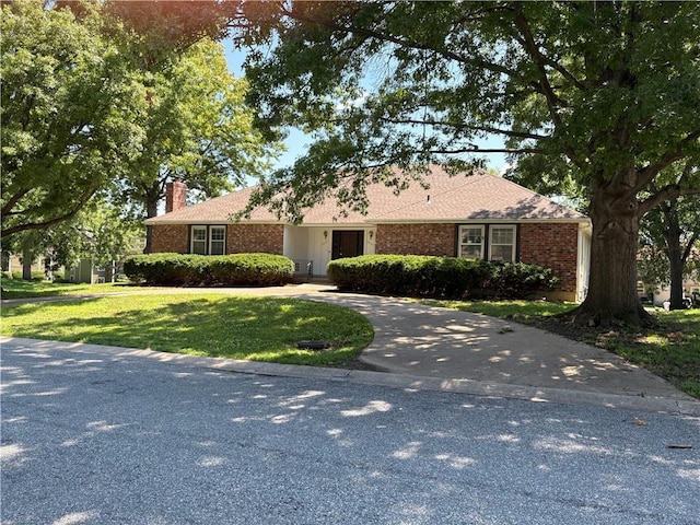10131 W 84th St, Overland Park, KS 66212 - single story home with a chimney, a front yard, brick siding, and concrete driveway