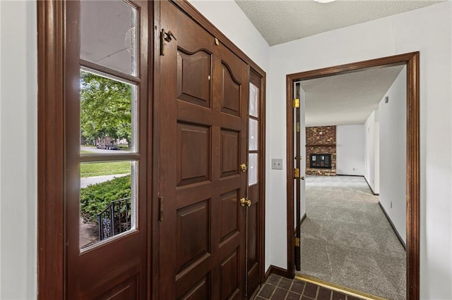 10131 W 84th St, Overland Park, KS 66212 - foyer entrance featuring dark colored carpet, a fireplace, and a textured ceiling