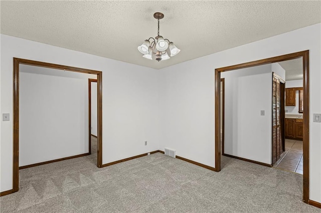 10131 W 84th St, Overland Park, KS 66212 - spare room featuring a chandelier, carpet, and a textured ceiling