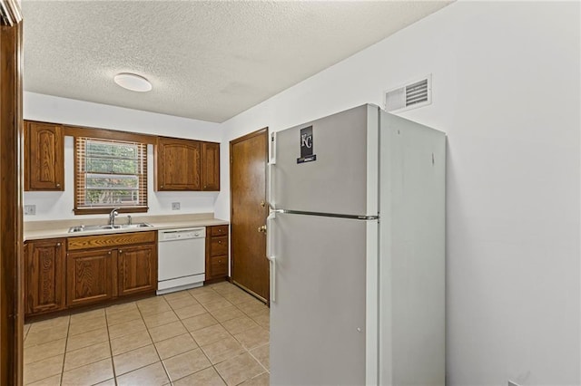 10131 W 84th St, Overland Park, KS 66212 - kitchen featuring white appliances, light countertops, a textured ceiling, light tile patterned floors, and brown cabinets
