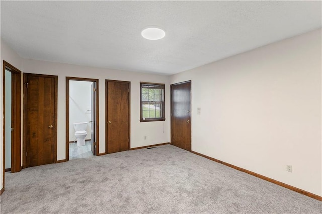10131 W 84th St, Overland Park, KS 66212 - unfurnished bedroom with light carpet, ensuite bath, and a textured ceiling