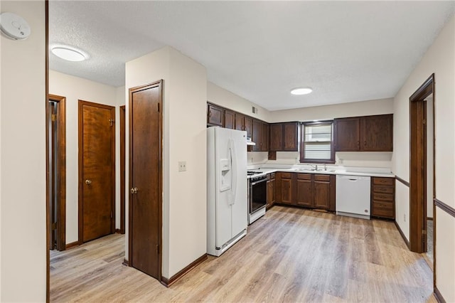 10131 W 84th St, Overland Park, KS 66212 - kitchen featuring white appliances, light wood-style flooring, light countertops, and dark brown cabinetry